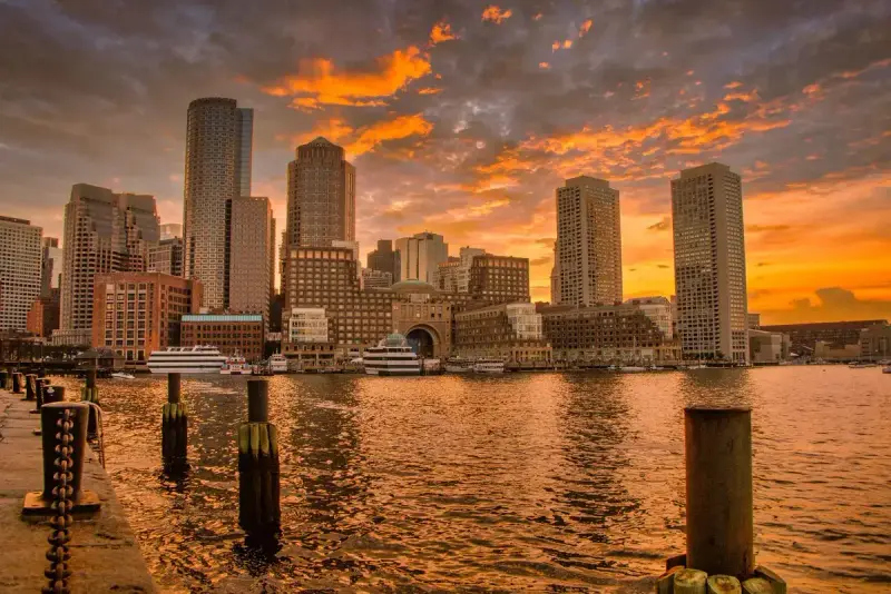 Boston skyline reflected in the harbor at sunset