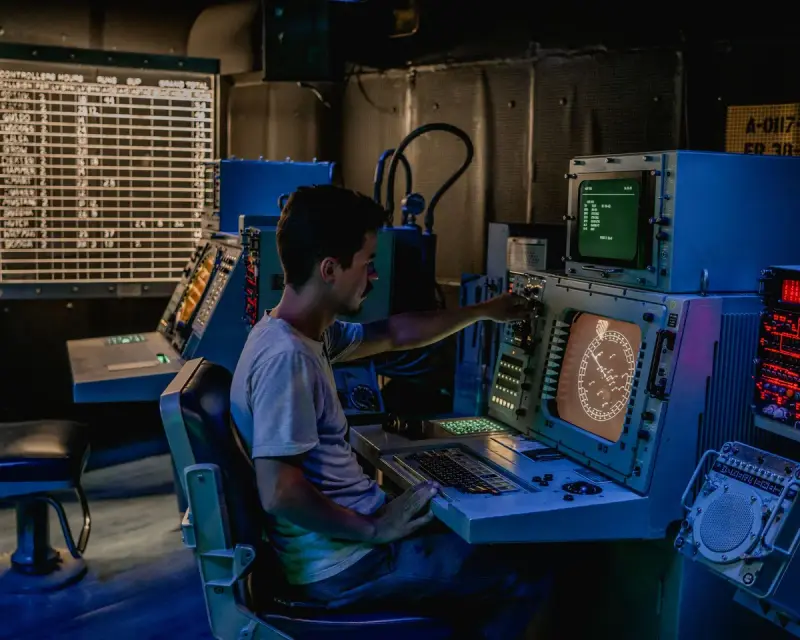 Operator working at control panels and screens in a plant control room
