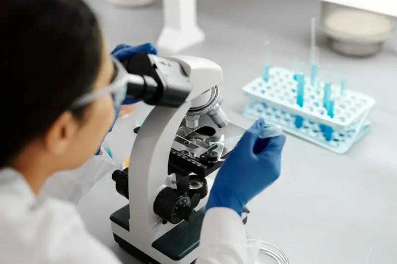 Scientist using a microscope and dropper during research