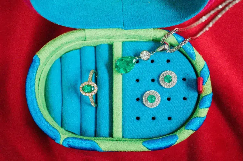 Emerald earrings and ring set in an open turquoise jewelry case