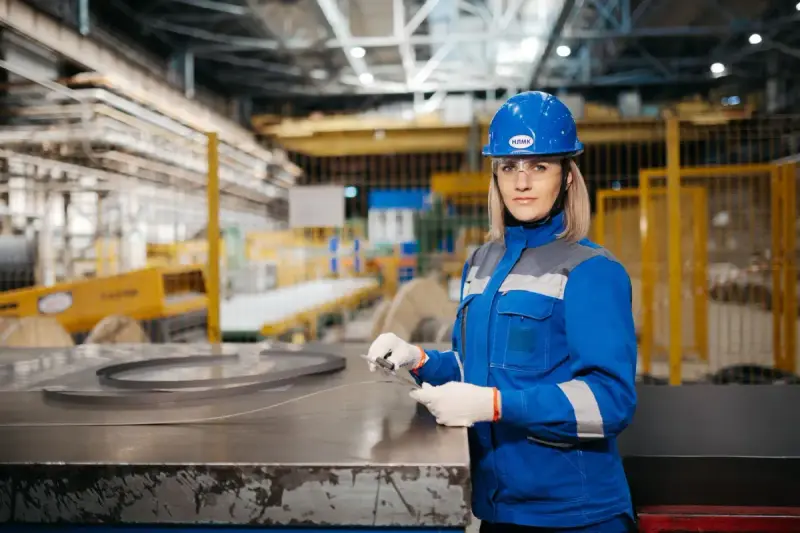 A woman working with industrial equipment in a factory.