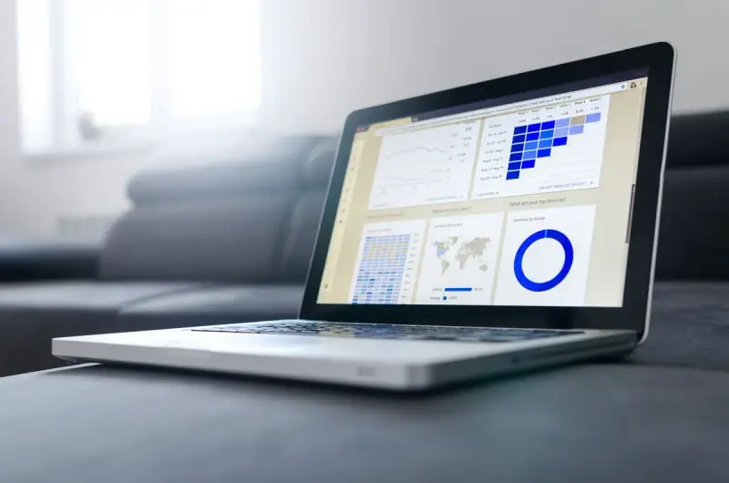 Laptop screen showing an analytics dashboard with charts and a donut graph