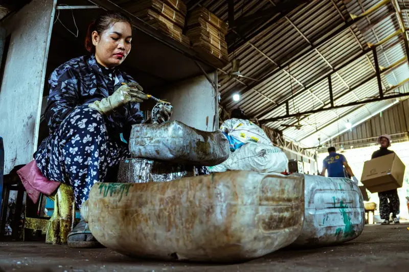 Woman working with recycled materials inside an industrial recycling facility