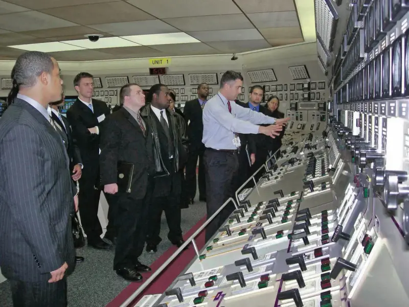 Nuclear power plant control room with operator consoles and wall panels