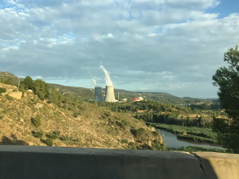Nuclear plant cooling towers rising above a green river valley