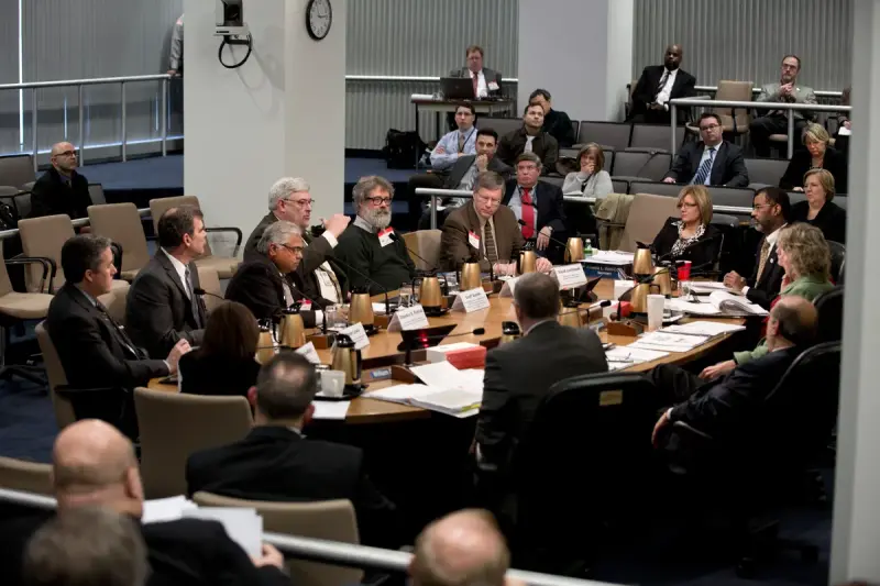 Technical experts presenting at a table during a public briefing on spent nuclear fuel safety