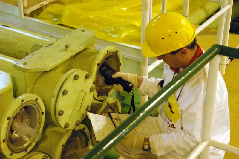 Inspector checking a nuclear fuel assembly during a safeguards training exercise