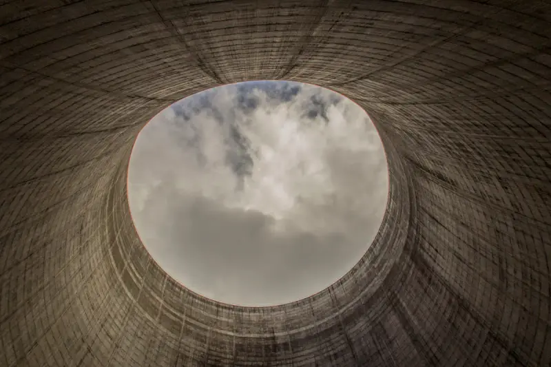 Looking up through the open top of a concrete nuclear cooling tower to the sky