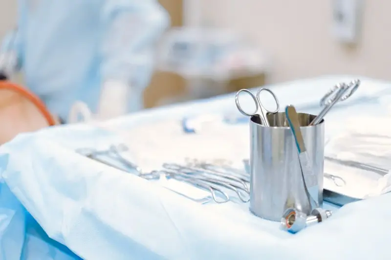 Close-up of surgical instruments laid out on a sterile table in an operating room