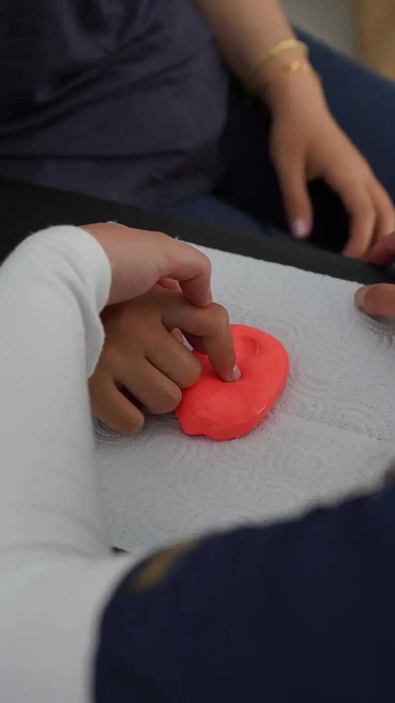 Close-up of hands working therapy putty to build fine motor skills