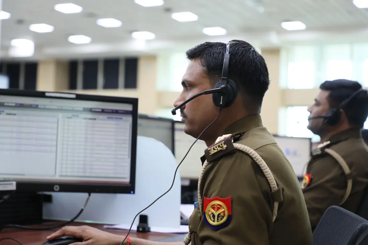 Uniformed dispatchers wearing headsets working at computer stations in an emergency dispatch center