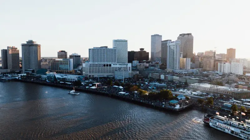 Downtown New Orleans towers above the Mississippi River riverfront at dusk