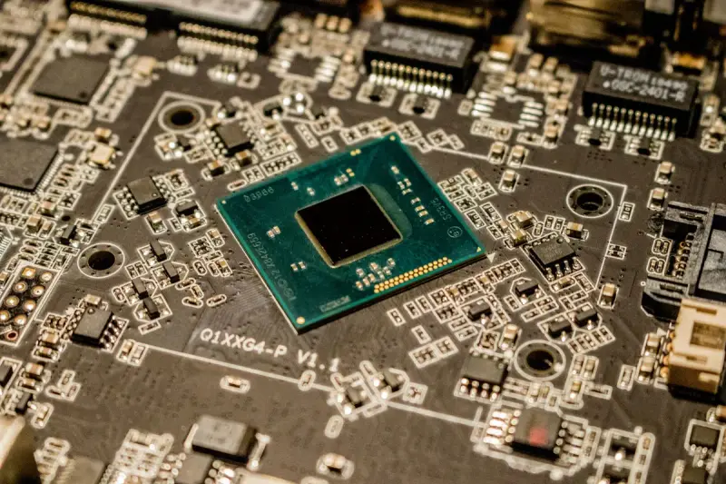Processor chip surrounded by small surface-mount parts on a dark printed circuit board