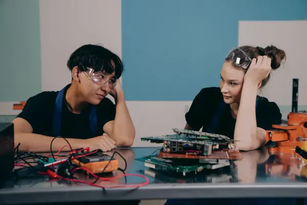 Engineers collaborating at an electronics workbench