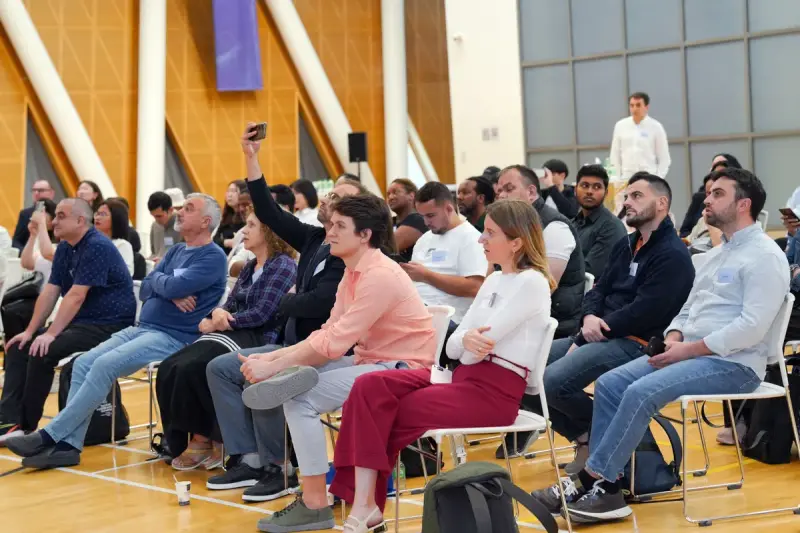 Large audience seated in rows listening to a speaker at an indoor seminar