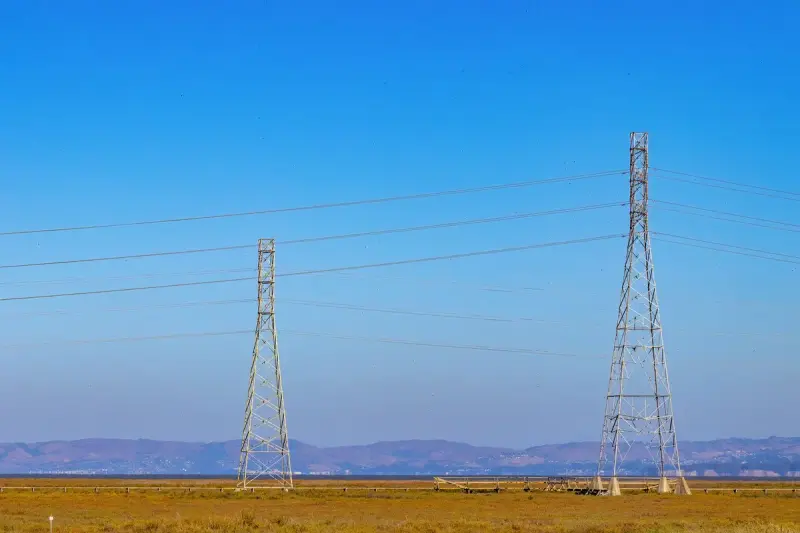Electric towers and power lines under a clear blue sky