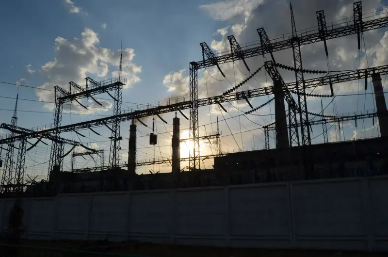 Silhouette of an electrical substation with the sun rising behind it