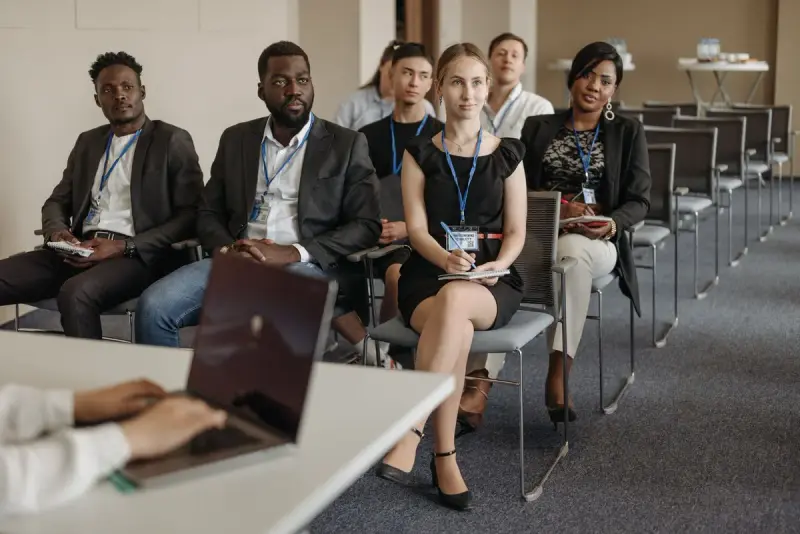 Group of people seated in a meeting room listening to a speaker