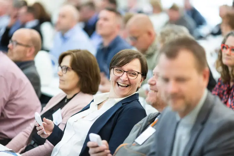 Adults smiling and talking during an indoor business meeting
