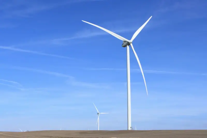 White wind turbines under a clear blue sky