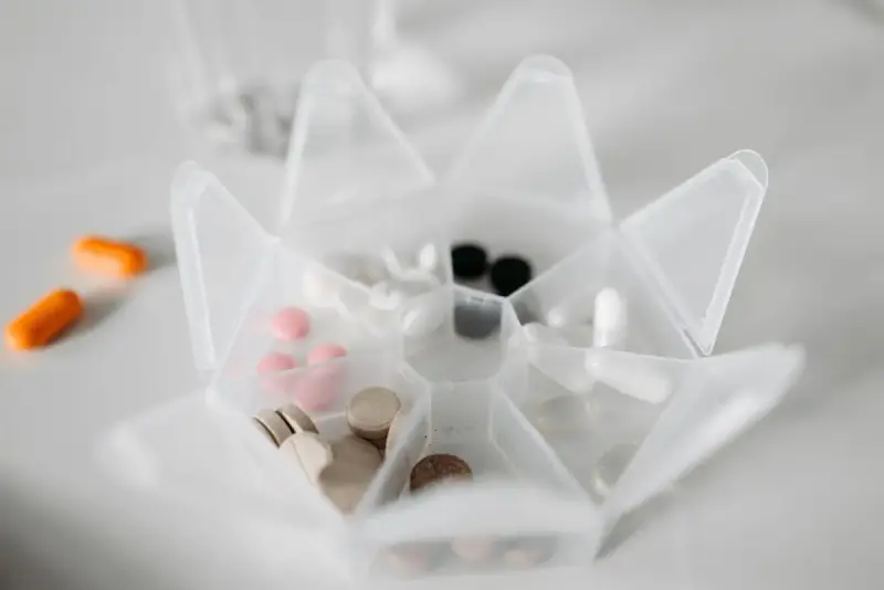 Clear star-shaped pill organizer holding white, pink and brown tablets