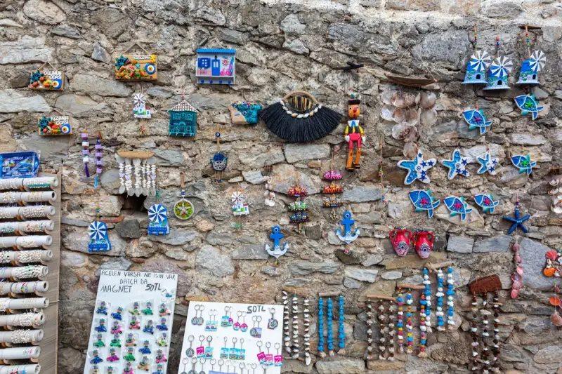 Colorful souvenir magnets, starfish and keychains pinned to a stone wall