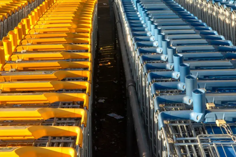 Long parallel rows of nested yellow and blue shopping carts