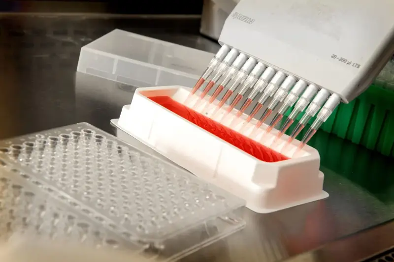 Automated pipetting system dispensing liquid into a plate in a laboratory