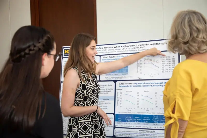 Researcher explaining a research poster to a small group of peers at a conference