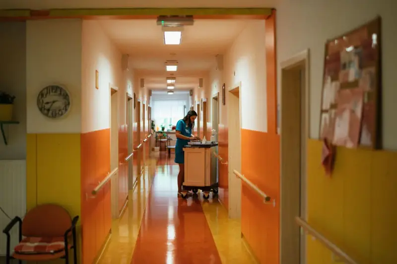 Nurse pushing a supply cart down a colorful hospital ward corridor