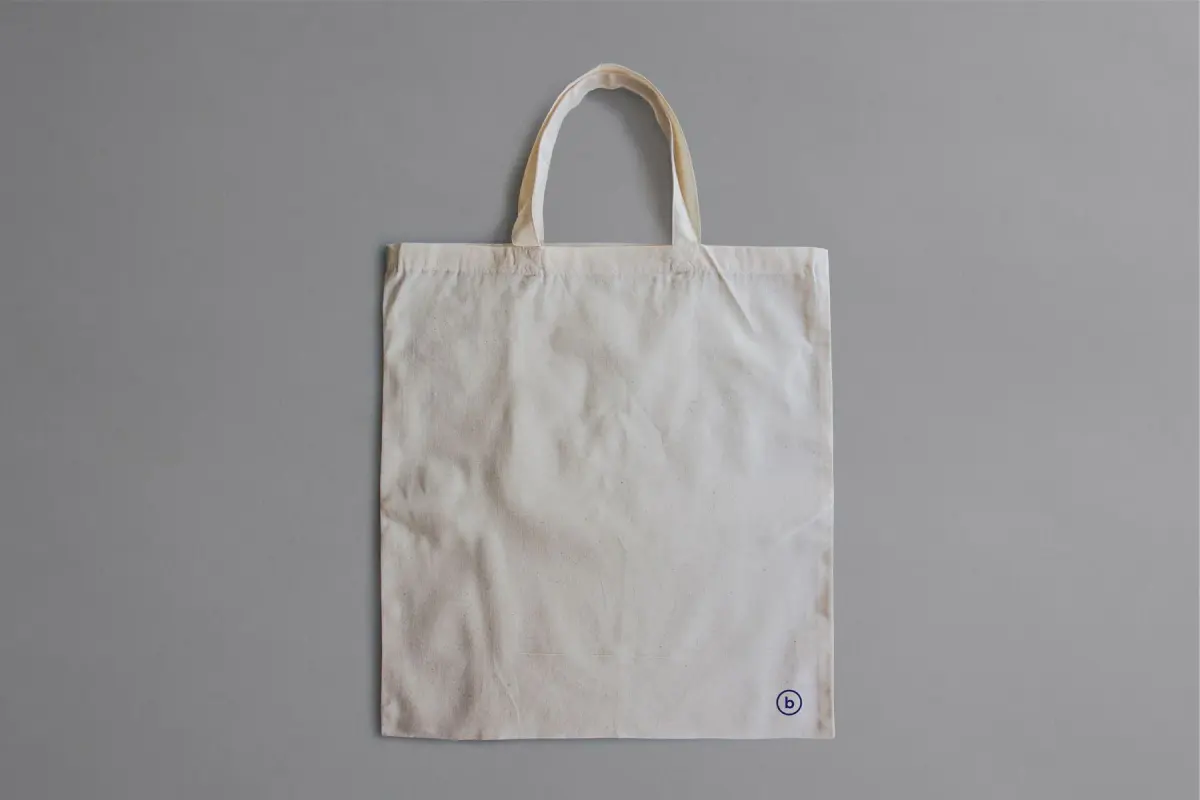 A plain canvas tote bag displayed against a neutral background.