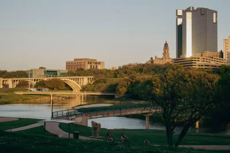 Fort Worth skyline above the Trinity River and its bridges in warm evening light