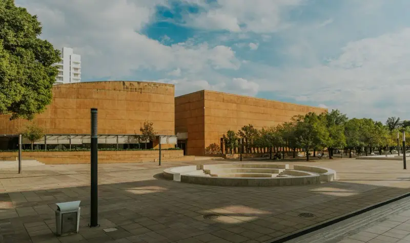 Open paved plaza in front of a modern building under a clear blue sky