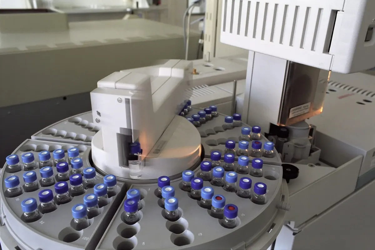Carousel autosampler loaded with blue-capped sample vials on a laboratory chromatograph