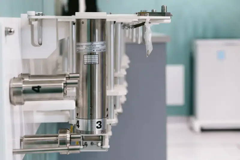 Numbered stainless steel cylinders and fittings mounted on laboratory apparatus