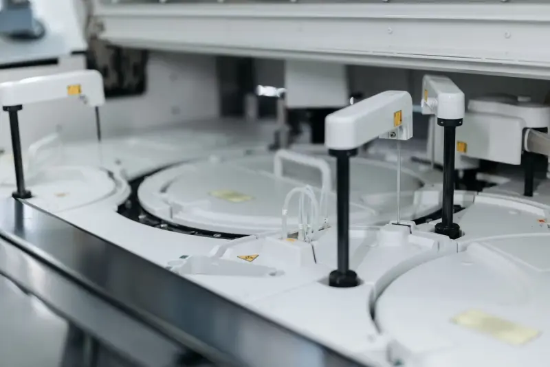 Close view of the sample carousel and probe arms inside a laboratory chemistry analyzer
