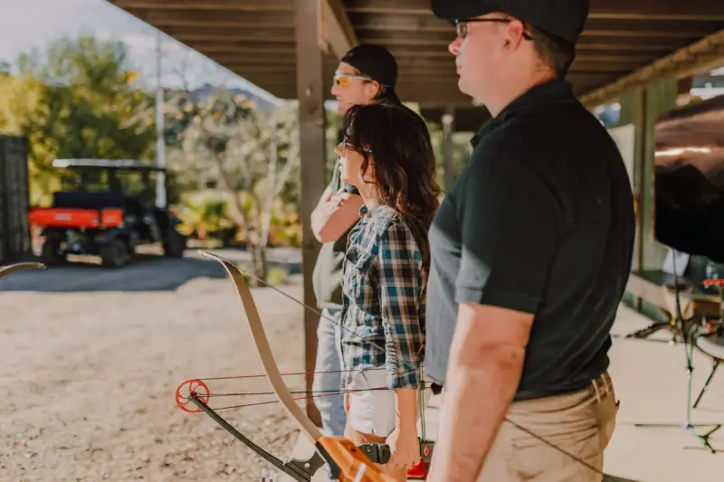 Group of adults with bows waiting their turn on a covered practice range