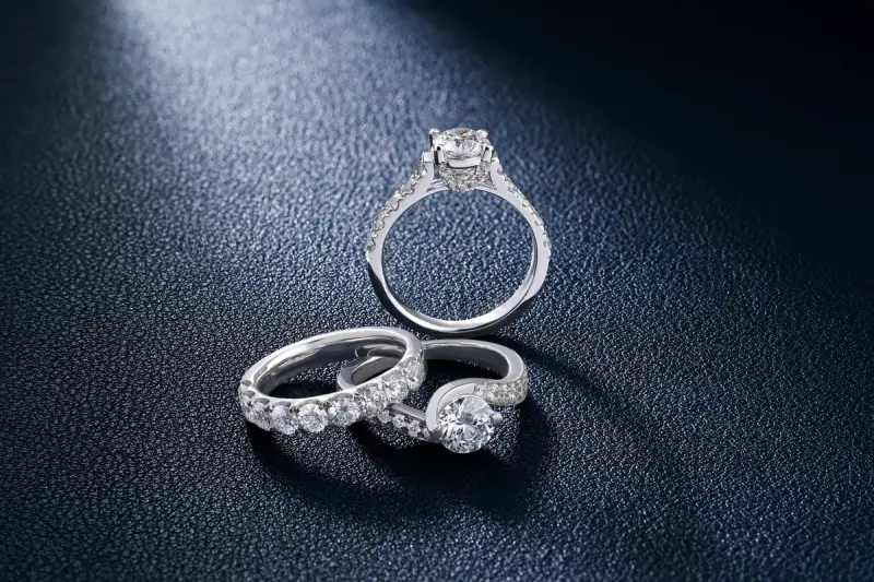 Diamond engagement and wedding rings on a textured surface