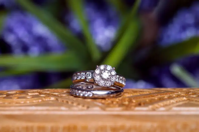 Diamond wedding rings resting on carved wood
