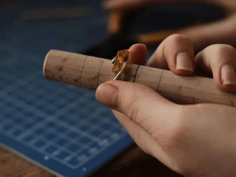 Jeweler shaping a gemstone ring on a ring mandrel
