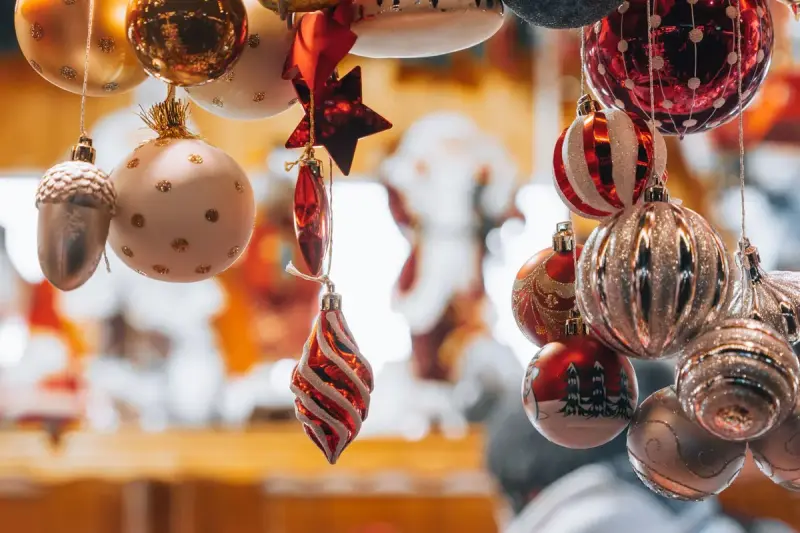 Glass and glitter Christmas ornaments hanging in a shop, with stars, baubles and an acorn