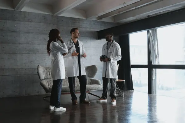 Three medical professionals discussing information in a bright office