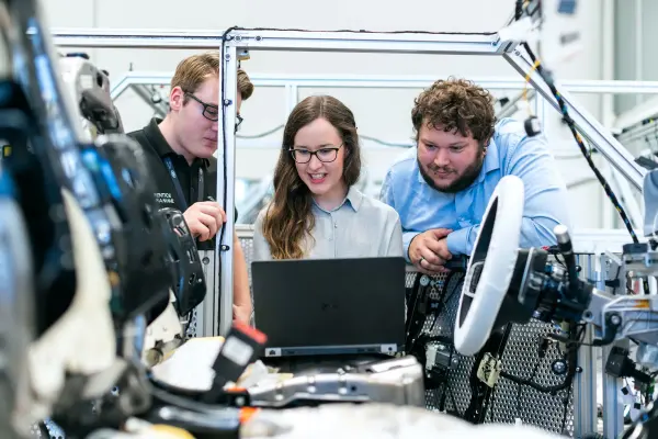 Engineers discussing a car project in an automotive workshop