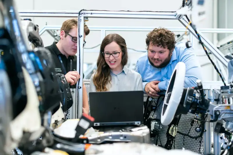 Engineers discussing a car project in an automotive workshop