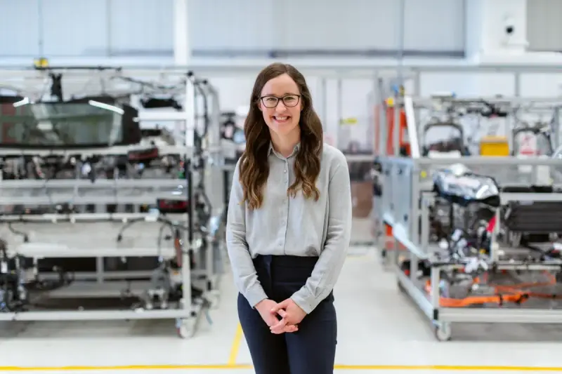 Smiling woman engineer standing in an industrial workshop