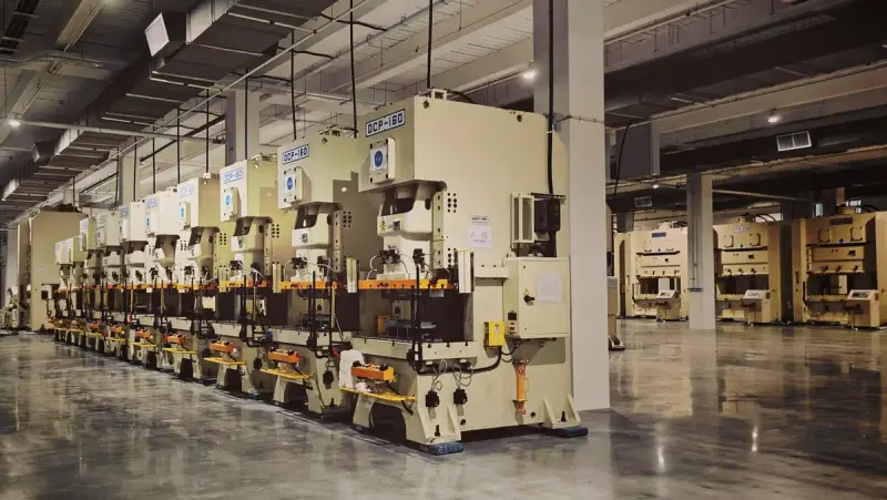 Row of stamping presses along a clean factory floor