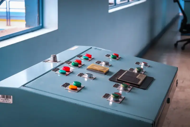 Blue operator console with red, green and orange push buttons and selector switches