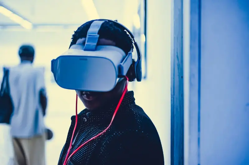 Young adult wearing a virtual reality headset and headphones in a modern room