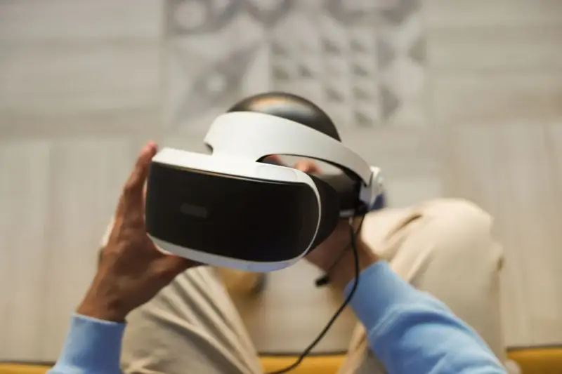Hands holding a white virtual reality headset close up