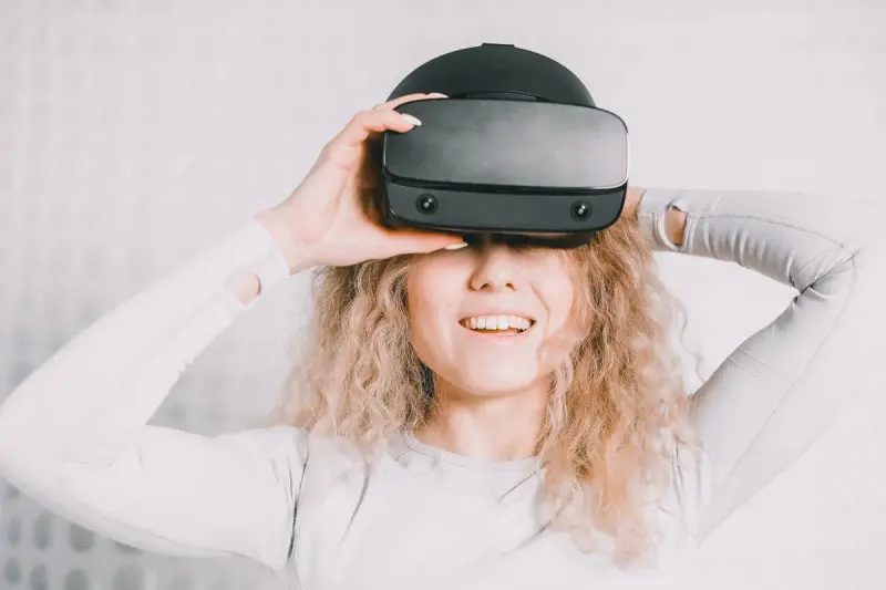 Smiling woman wearing a VR headset while trying a virtual reality experience